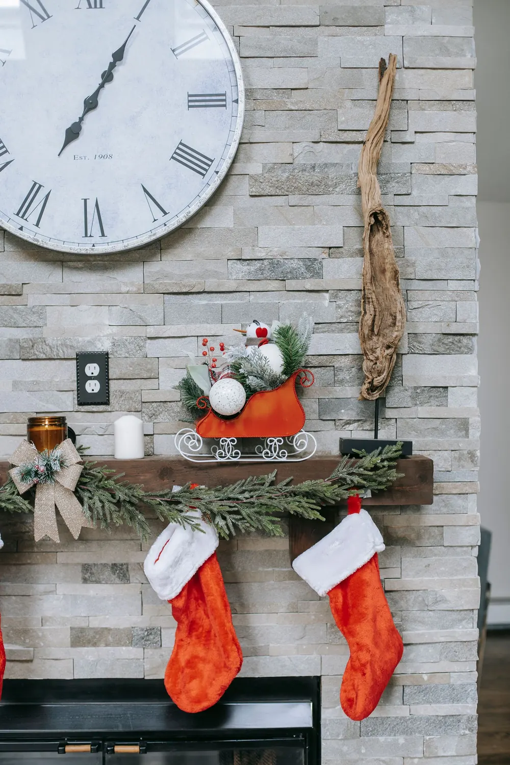 Cozy indoor holiday decor featuring stockings, sleigh, and a classic wall clock.