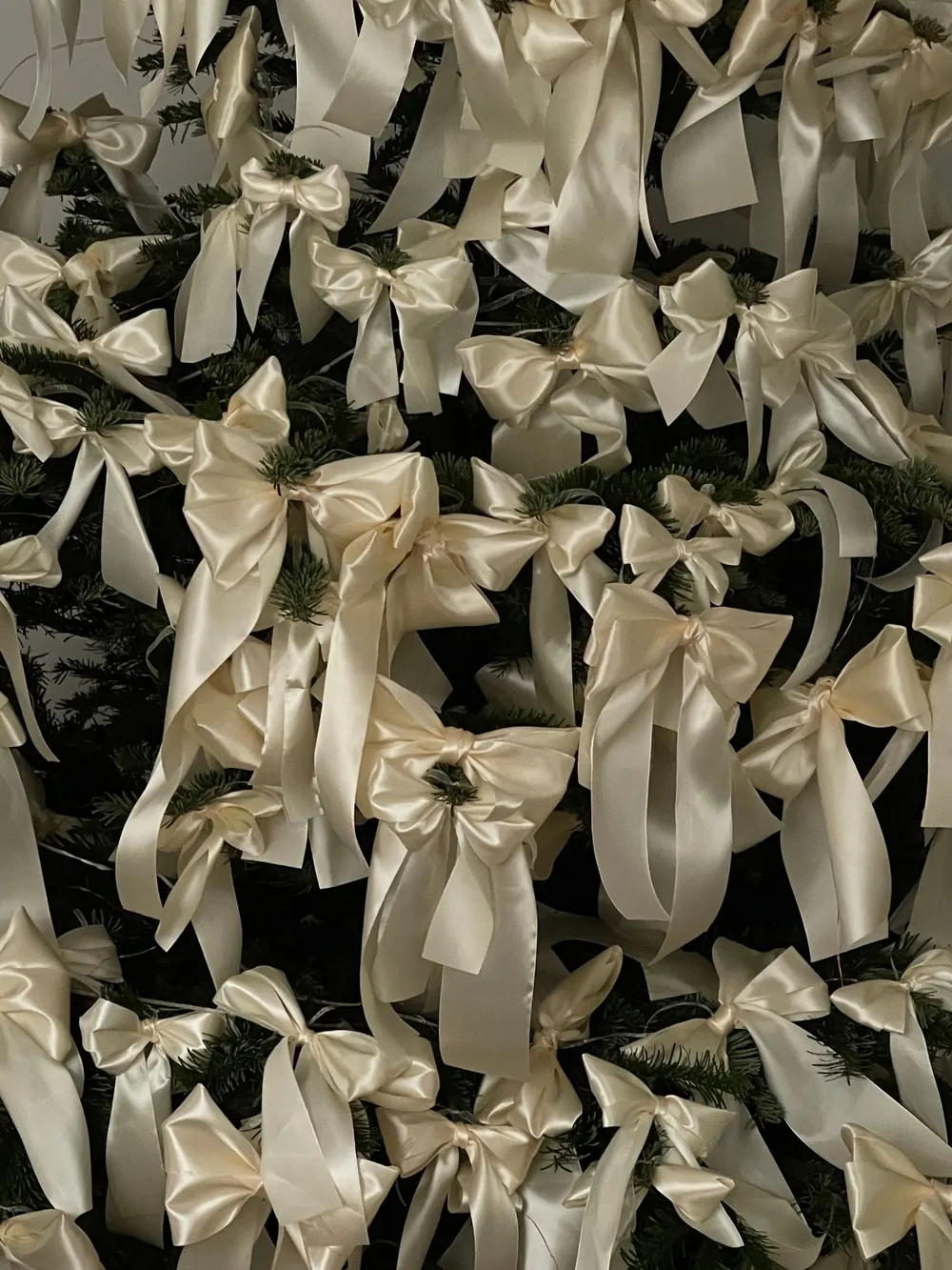 A beautifully decorated Christmas tree adorned with elegant white ribbons, capturing the festive spirit.
