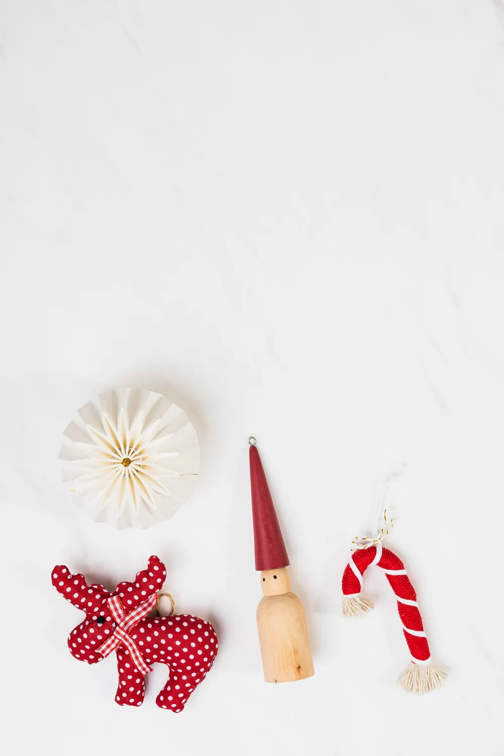 A festive and minimalist flat lay of Christmas decorations on a white background.