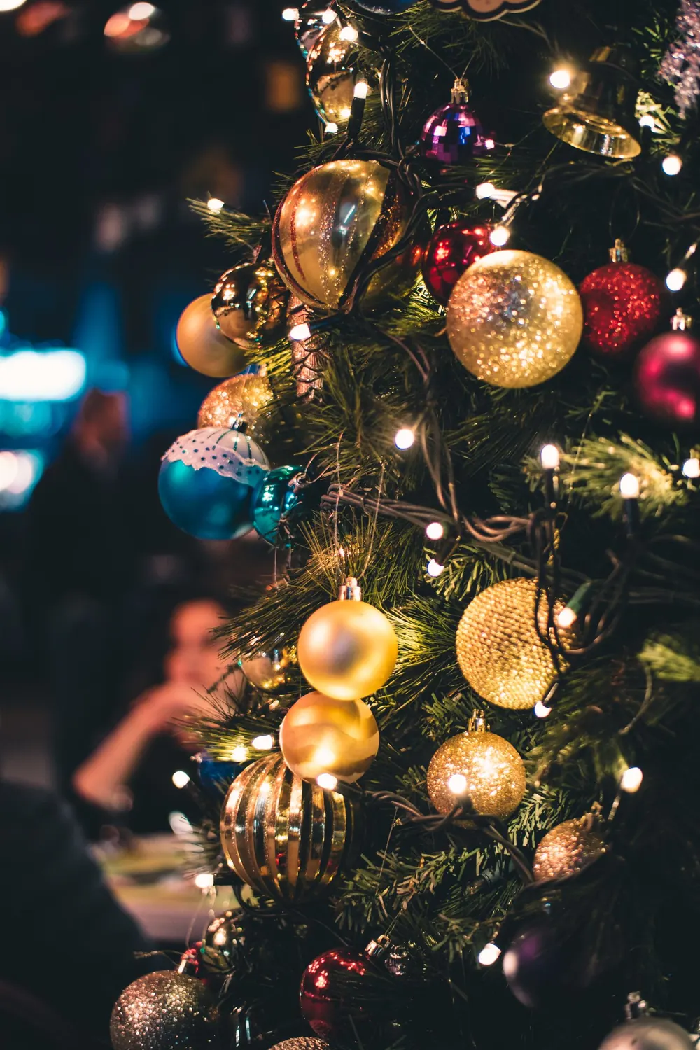 Close-up of a Christmas tree adorned with vibrant ornaments and lights.