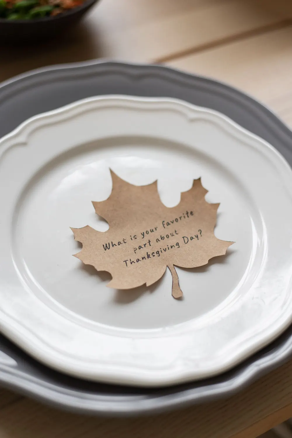 Elegant Thanksgiving table setting with a paper leaf cutout and festive question.